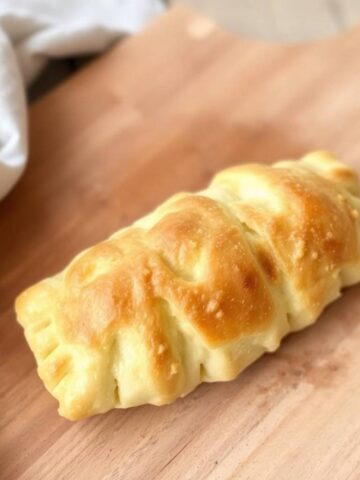 flaky gluten-free puff pastry on a wooden cutting board, using natural earth tones like browns and beiges to evoke a cozy, muted atmosphere